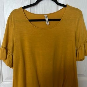 Mustard colored blouse, size XL, tie at the bottom and design on the sleeves